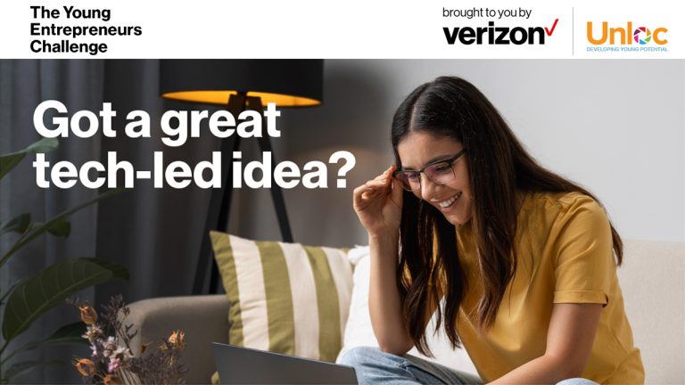 A woman sitting on a sofa with a laptop.