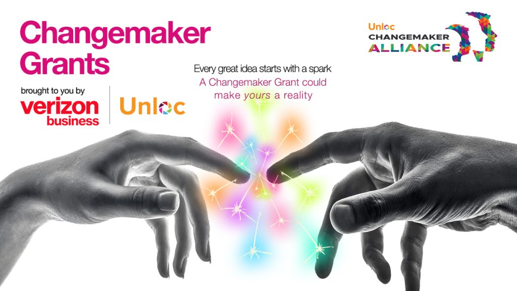 Two hands reaching towards each other with colourful sparks between them. Text promotes Changemaker Grants by Verizon Business and Unloc Changemaker Alliance.