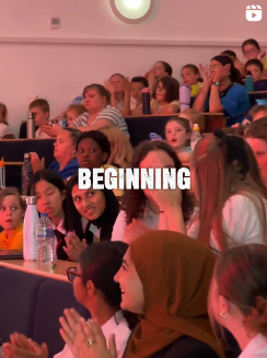 A diverse group of students sit and clap in a lecture theatre, with the word BEGINNING in bold white text across the centre.