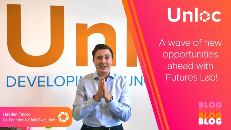 A man stands in front of an Unloc sign, smiling with hands clasped. Text reads, A wave of new opportunities ahead with Futures Lab! and identifies him as Hayden Taylor.