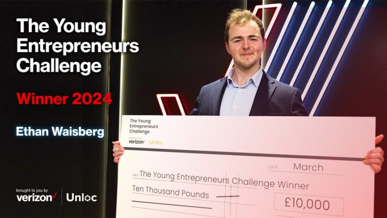 A man in a suit holds a large cheque for £10,000 as the 2024 winner of The Young Entrepreneurs Challenge, with event branding in the background.